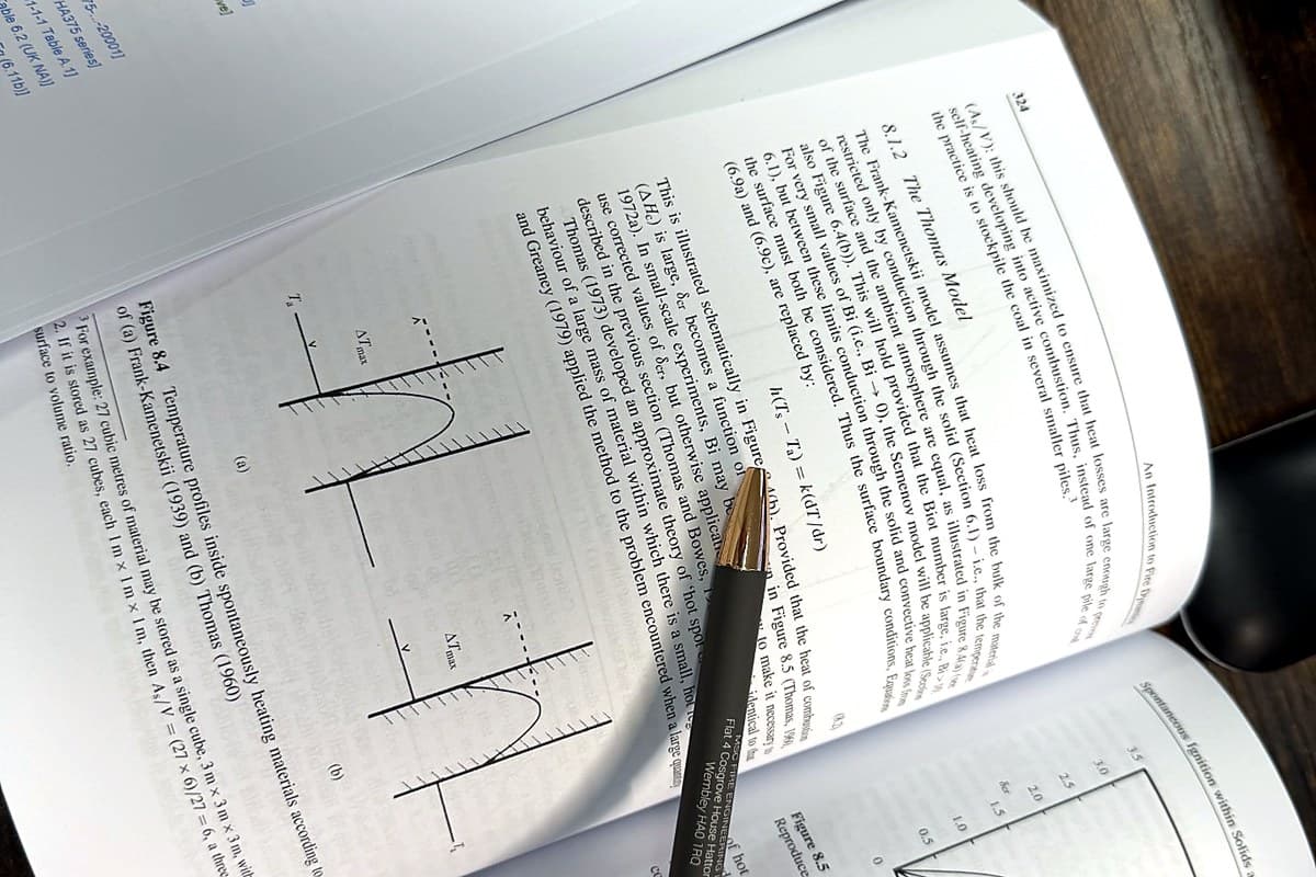 Fire engineering textbook open on a desk with an MSC Fire Engineering pen